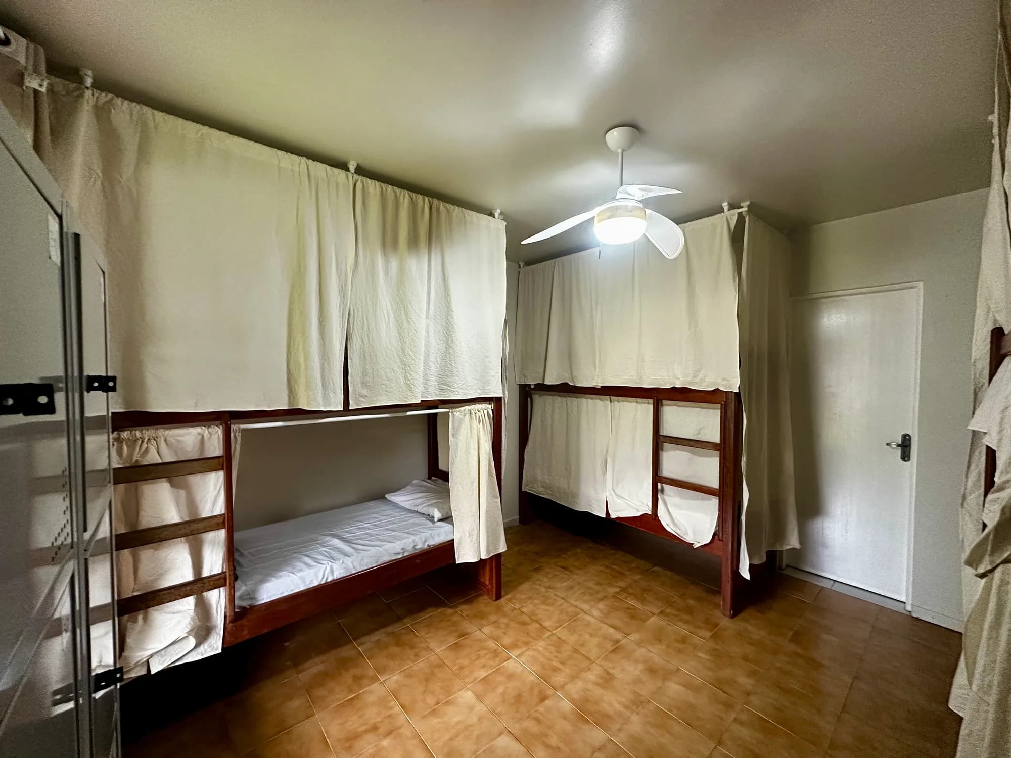 Dormitório misto com beliches e cortinas